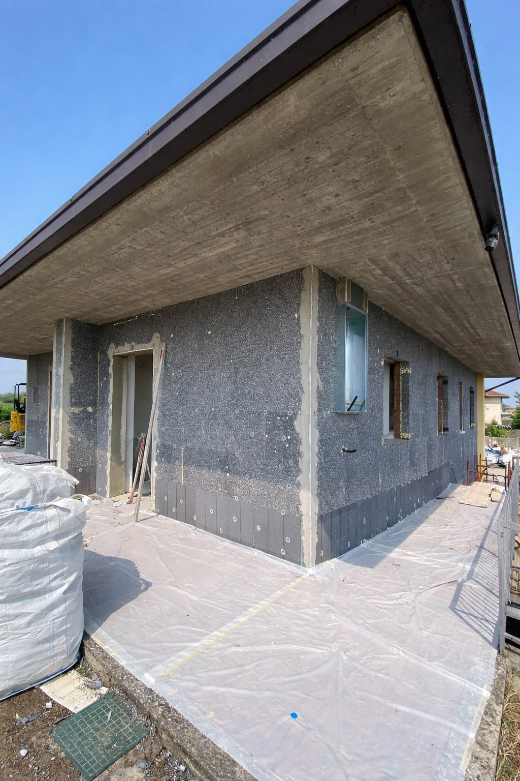 Posa del pannello isolante su facciata — cantiere cappotto termico Brescia